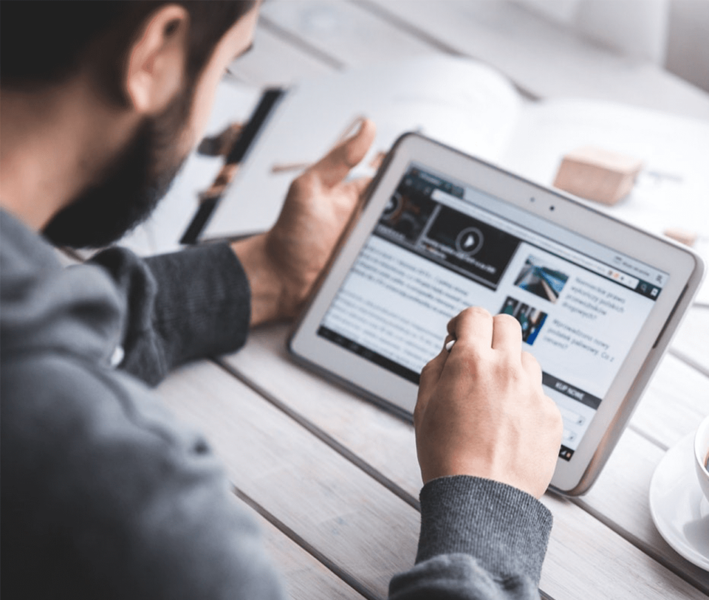 Man scrolls the news on his tablet