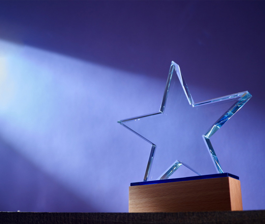 Award with a blank acrylic star sitting on a desk.