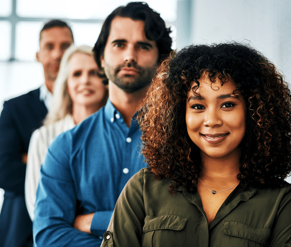 Confident, diverse group of 4 people standing behind each other signifying unity and teamwork.