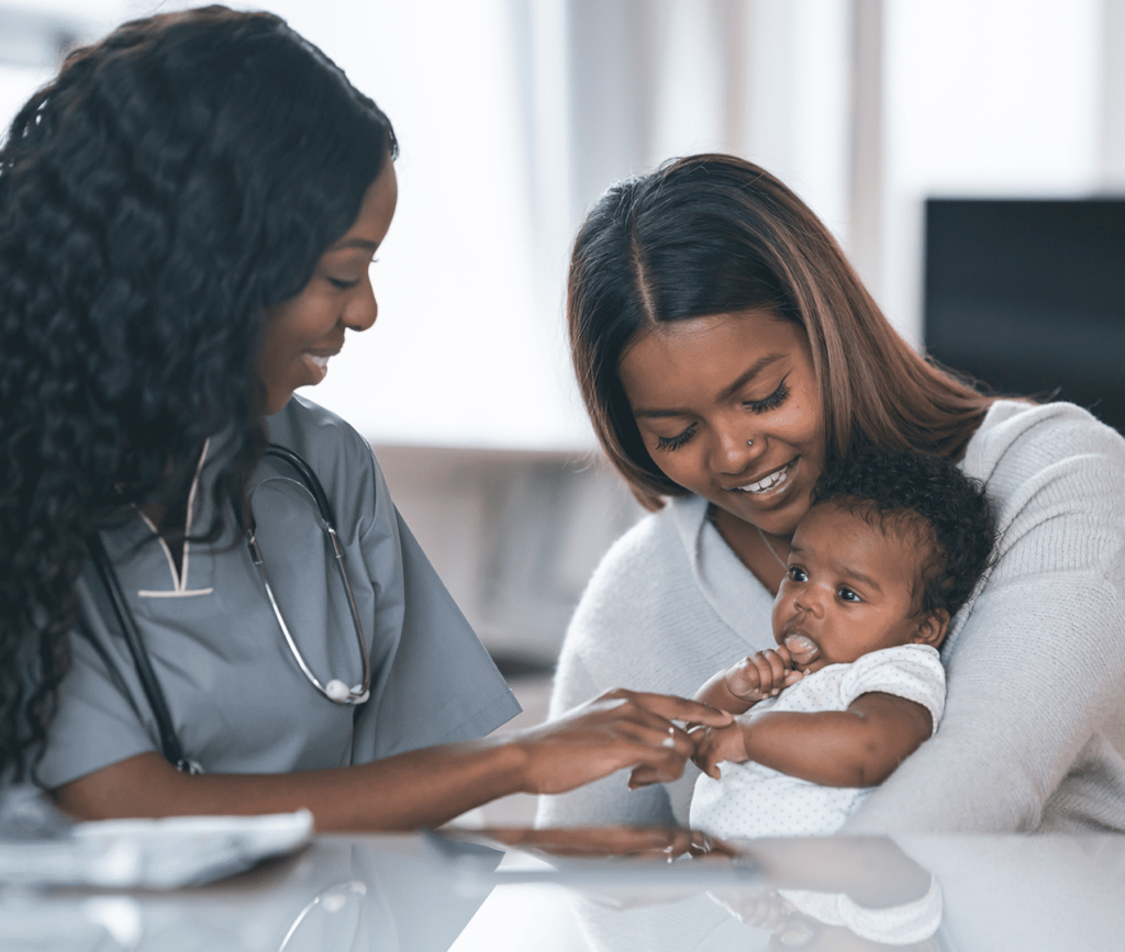 Joyful mother holds her infant child for the doctor to do a routine checkup exam.