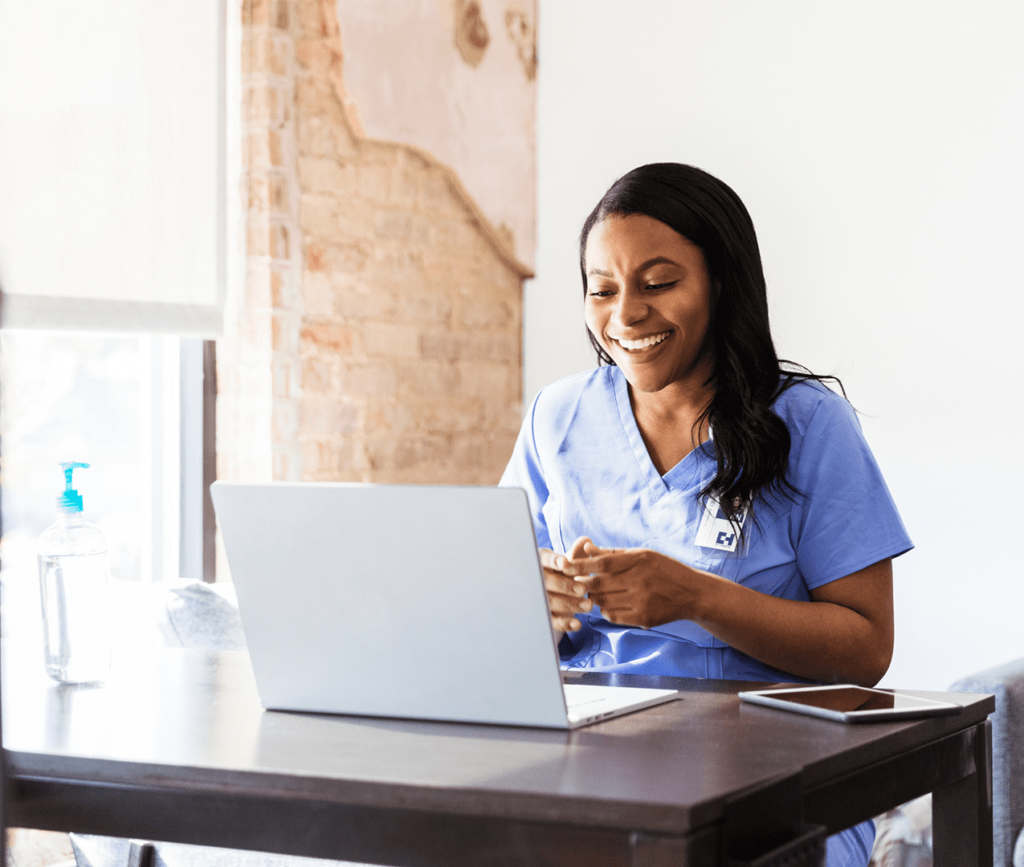 Doctor looking at her computer as she sits at her desk conducting a virtual doctor appointment.