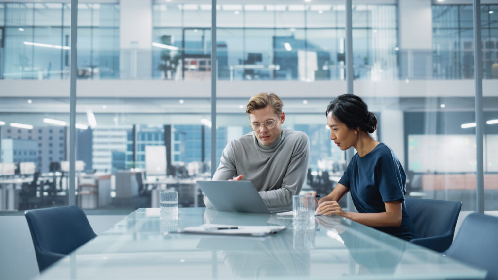 Two clinical researchers brainstorming in a modern office