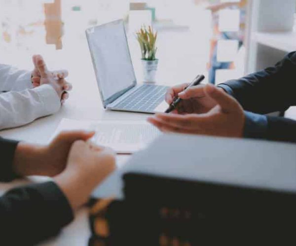 Close up concept of businessman sitting across the table from colleagues and giving a consultation.